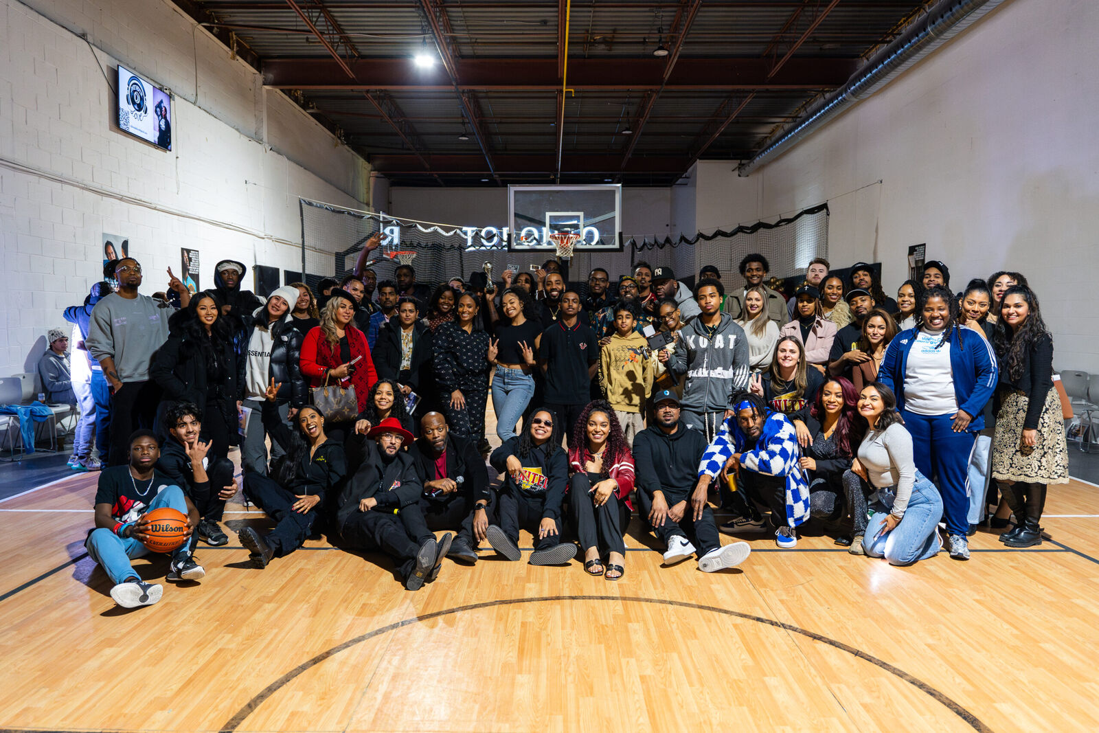 Large group photo of guests gathered on the court at a community event