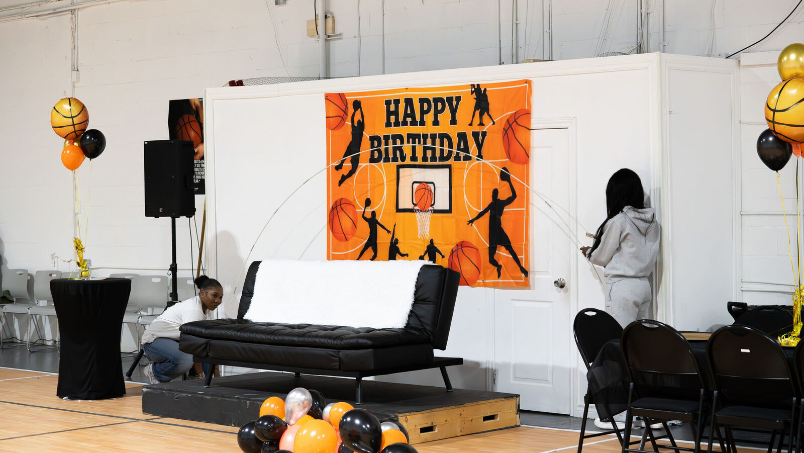 Birthday party setup on the court with a Happy Birthday banner and lounge seating