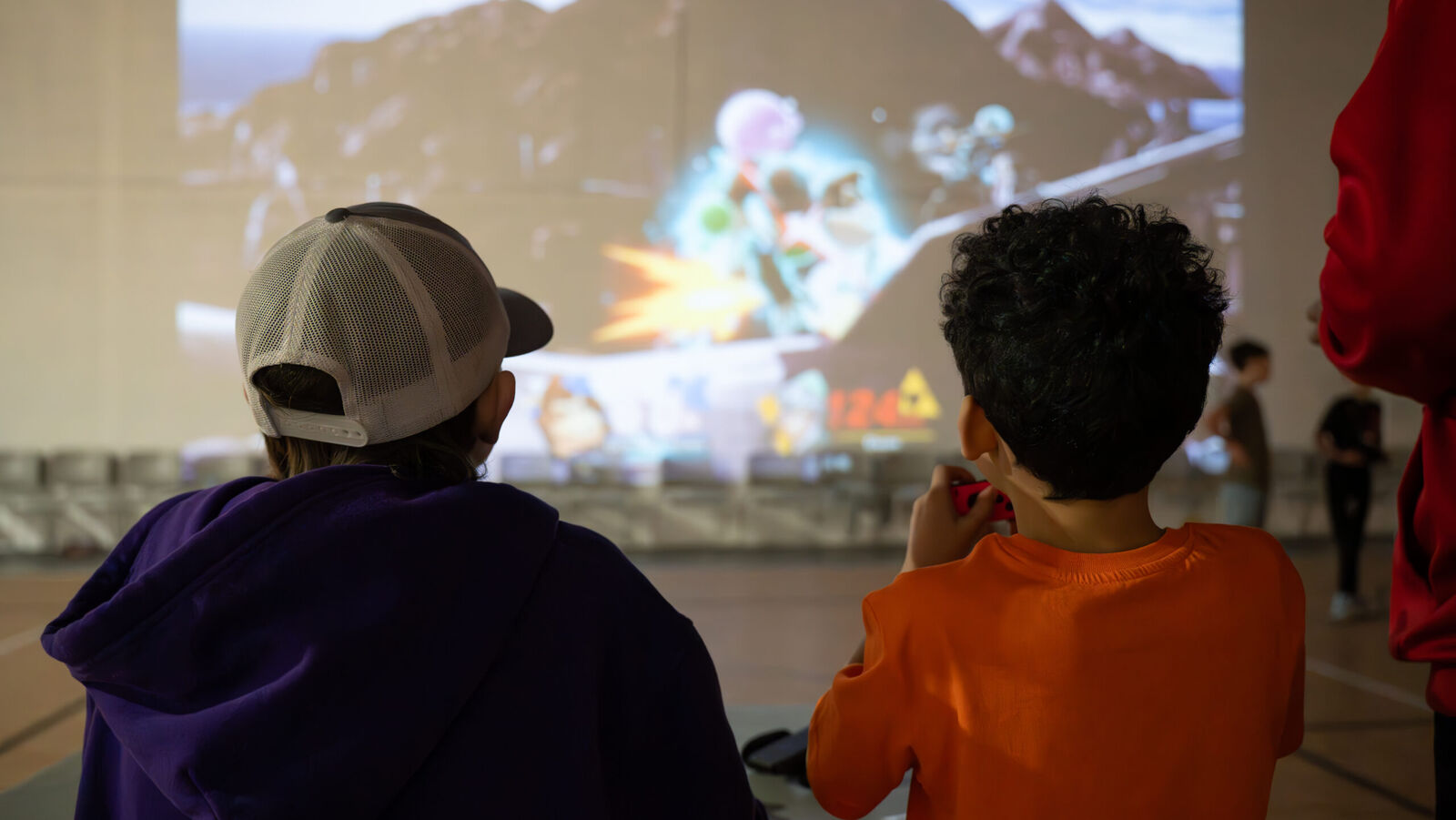 Kids gaming together in front of the 55-foot screen